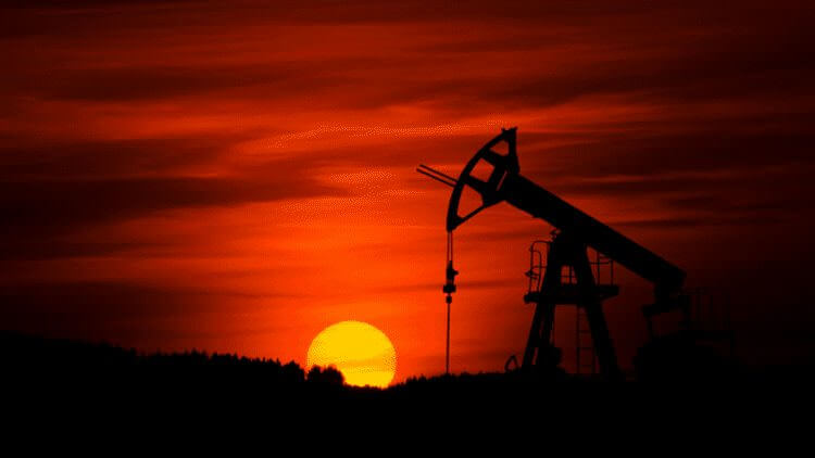 oil rig against red setting sun