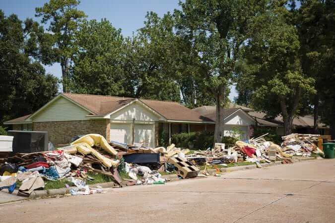 Houston Texas USA September 10 2017: Damaged houses on one of the streets. After hurricane Harvey. Trash and damaged households outside the houses.