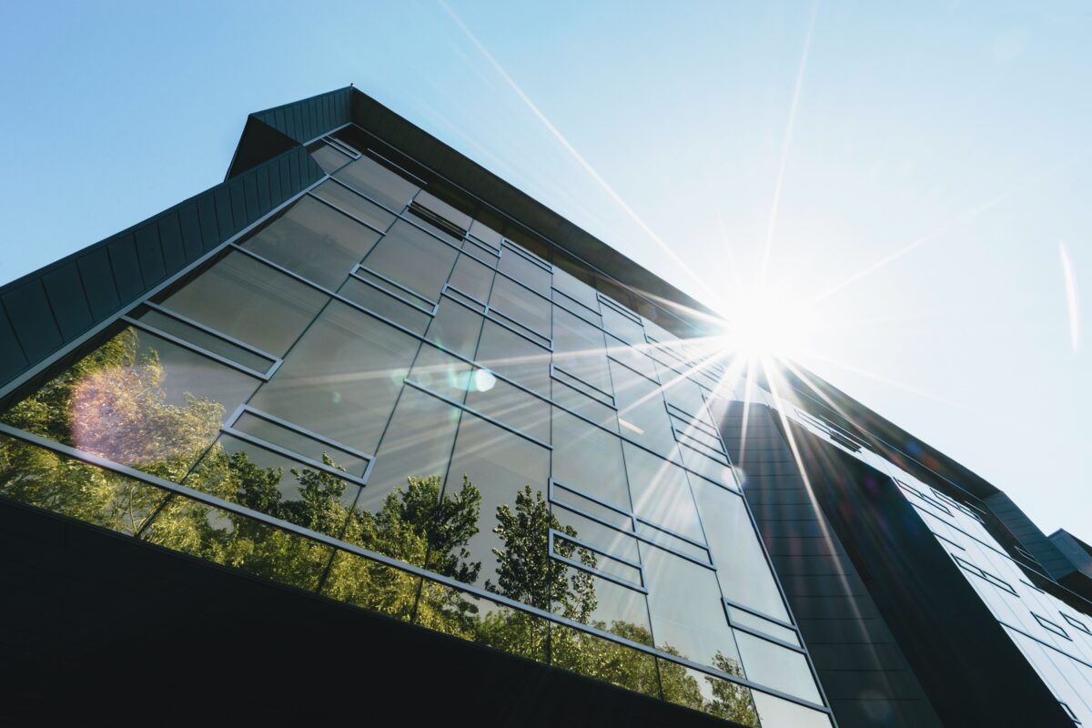 building reflecting sunshine and greenery for article about which us state has best record for green energy