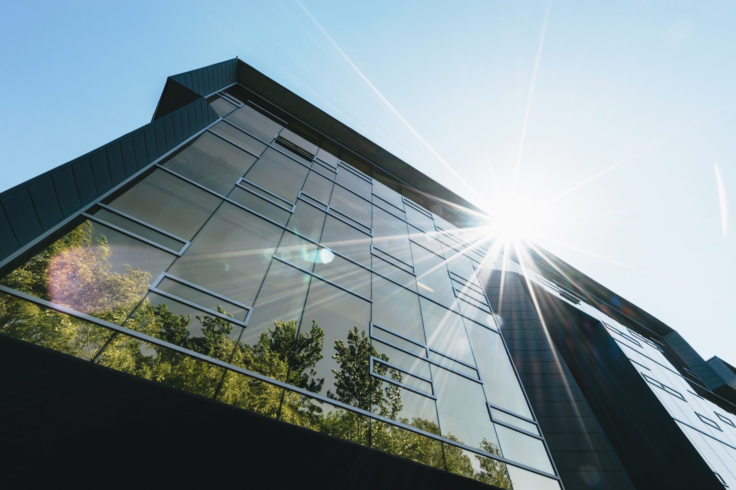 building reflecting sunshine and greenery for article about which us state has best record for green energy