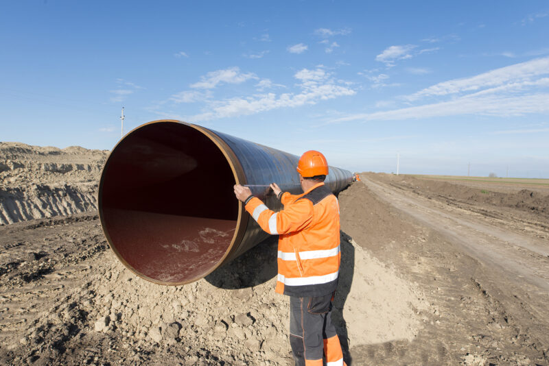 pipeline workers measuring tube length for construction of gas a