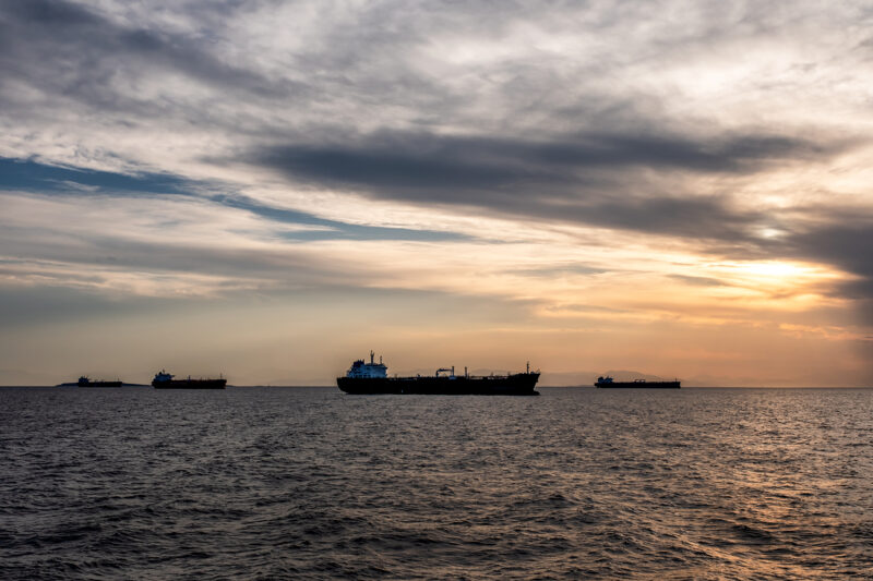 The New Energy Bottleneck Reshaping Global Energy Ships on the sea at sunset.